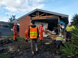 First responders preparing a temporary repair to a damaged building.
